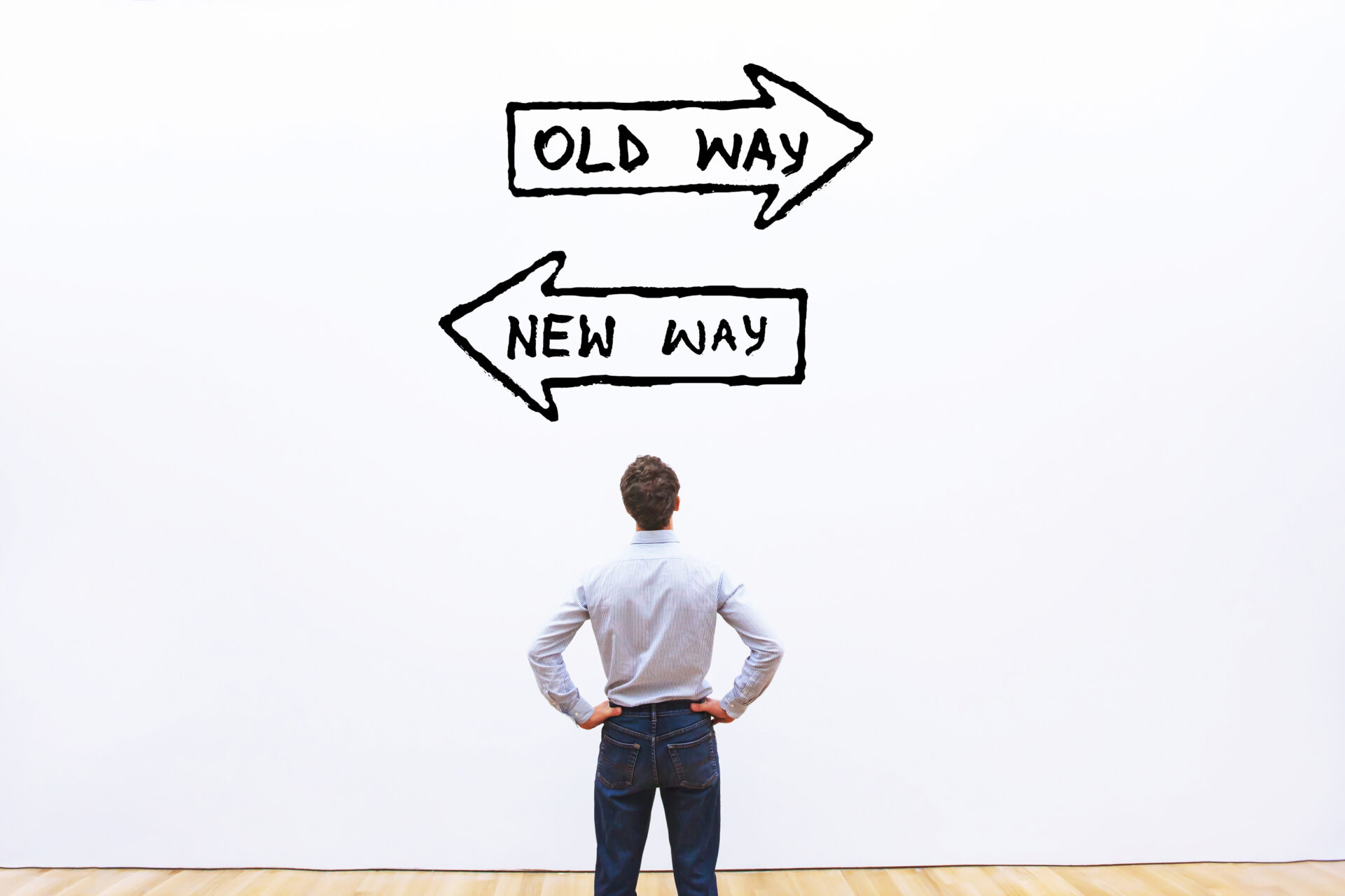 Man staring at a wall with old way and new way arrows