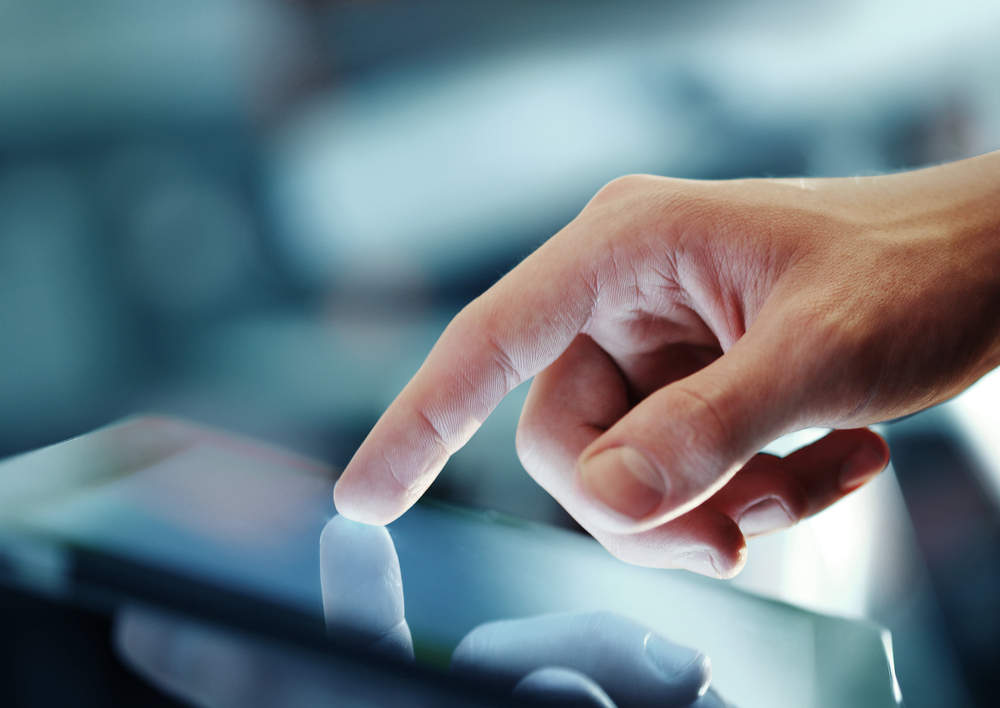 Finger touching tablet screen