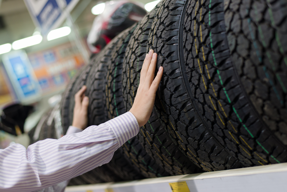 Man touching tires on a rack