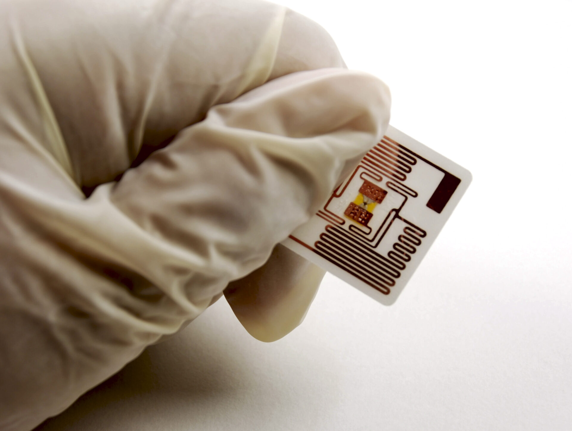 Gloved hand holding an RFID label