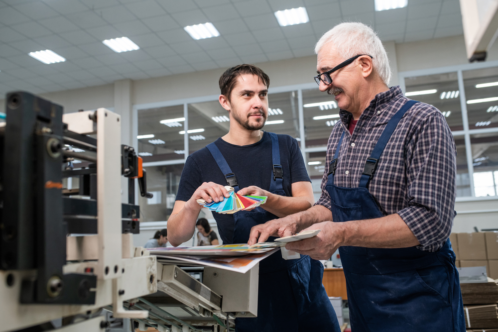 Workers discussing colors by printer