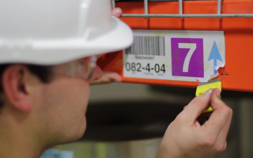 Warehouse worker scraping off a label