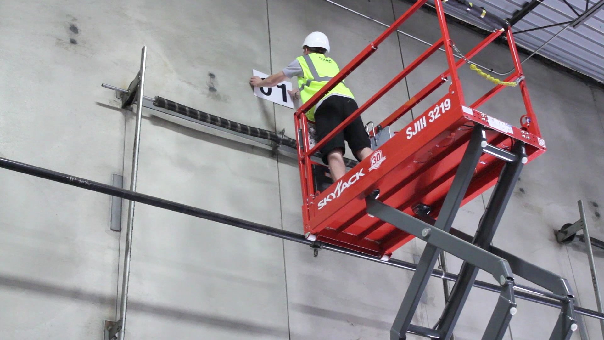 Man installing a sign while on a lift