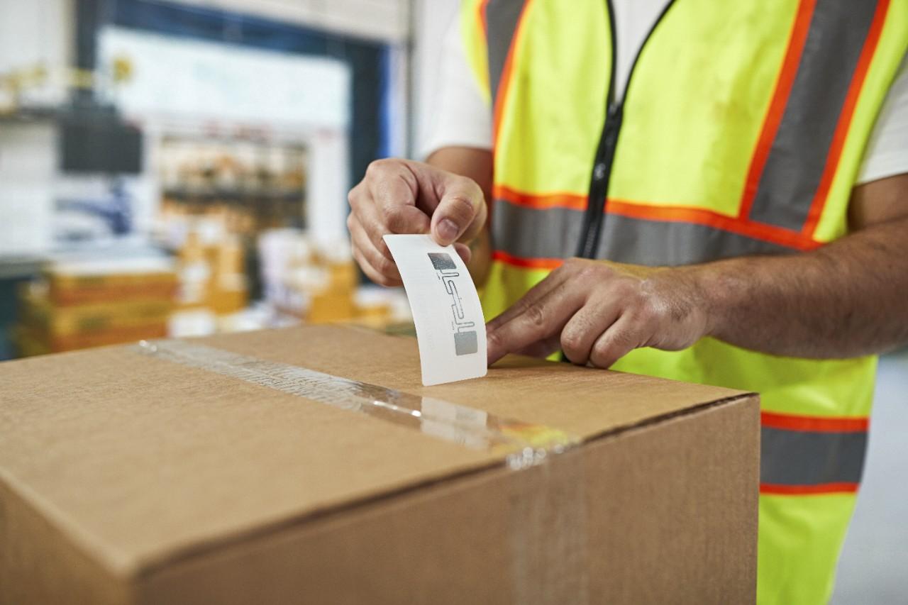 Pharmacist scanning price on a red medicine box with barcode reader in pharmacy store